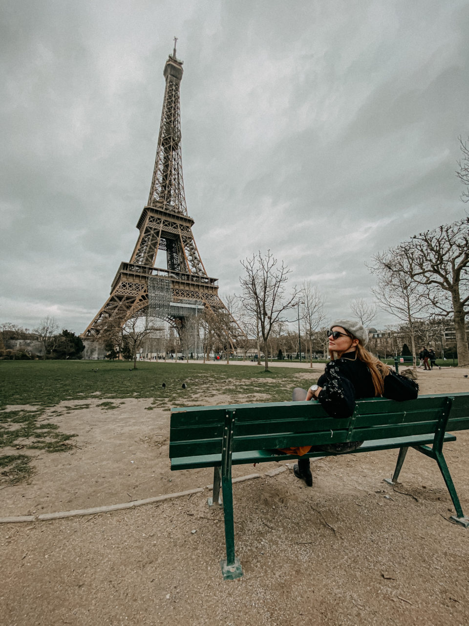 Frau auf einer Bank in Paris in der nähe des Eiffelturms